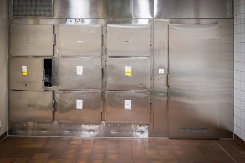 Hospital, morgue, pathology, cold room with metal doors and sterile-looking surroundings, tiled
