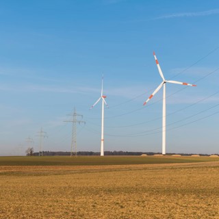 Wind turbines and power lines in an autumnal field under a clear sky, solar park, near Ulm, Swabian