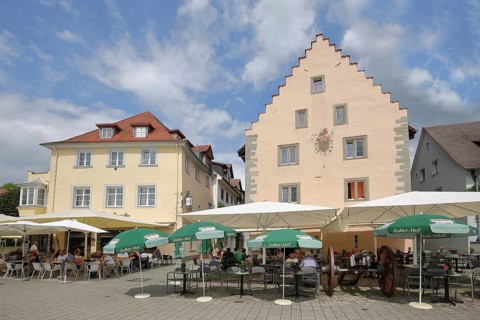 Historic armoury with stepped gable and street pub, cannon, sunshades, lakeside promenade,
