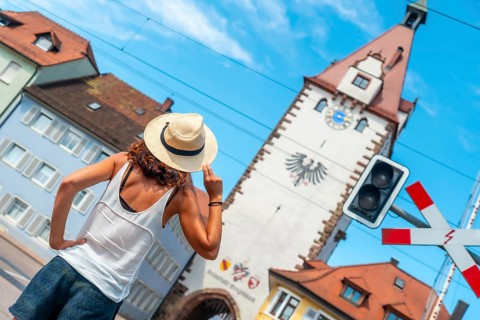A female tourist at the Kinzigtor tower in the village of Gengenbach in the Black Forest, Germany,