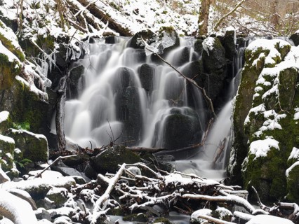 Teufelsmühle waterfall on the hill stream the Schwartzbach, in snow and ice in November. The Rhön