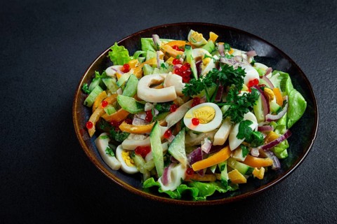 Salad with squid, fresh cucumber, eggs, sweet pepper, red onion, with dressing, homemade, no people