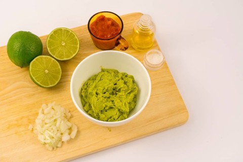 Crushed avocado in a white bowl. Recipe to prepare a nice guacamole