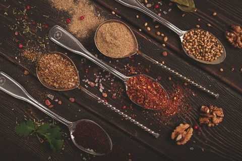 Georgian spices in spoons, on a wooden background, top view, no people