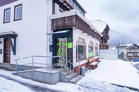 Snow-covered building with wooden details in a mountainous village in cold weather, Tante M,