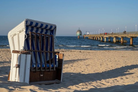 Beach chair on the sandy beach, tourists on the Vineta Bridge, pier with diving gondola, Zinnowitz,