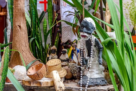 Afro-Brazilian religious altar with Umbanda objects and entities among plants, Belo Horizonte,