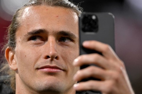 Tennis player Alexander Zverev visiting a Bundesliga match, portrait, takes selfie with smartphone,