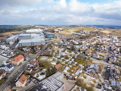 Bird's eye view of industrial area and neighbouring residential buildings in winter landscape,