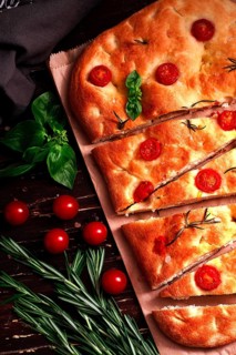 Focaccia, Italian flatbread, with cherry and rosemary, close-up, garlic bread, top view, vertical,