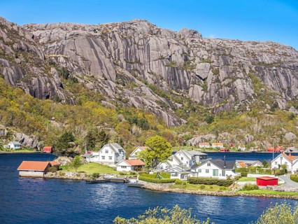 Steep granite mountains at the sea near Ana Sira, village Stornes, typcial coastal village, at