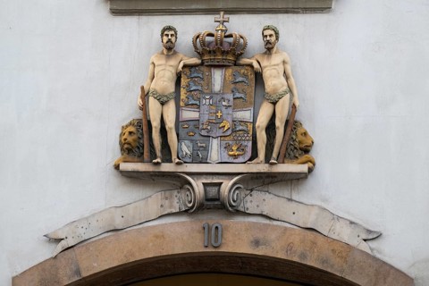 Coat of arms with crown and two men, Stormgade 10, Copenhagen, Denmark, Europe