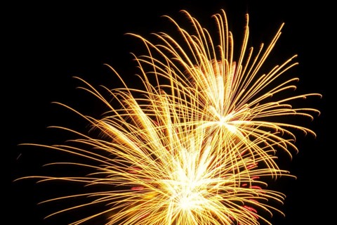 New Year's Eve fireworks, vivid fireworks in the night sky with golden, yellow stripes of light and