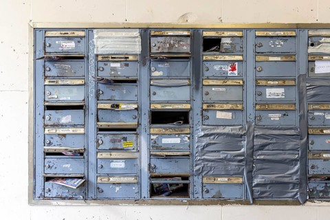 Doorbell sign, broken letterbox system on a dilapidated block of flats in Stuttgart,