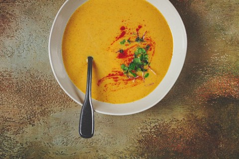 Pumpkin cream soup, in a white bowl on a textured background, top view, homemade, no people, rustic