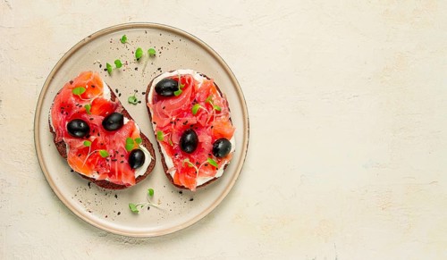 Sandwiches with red fish, cream cheese, olives and microgreens, breakfast