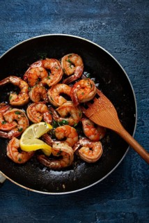 Fried tiger prawns, jumbo, in garlic sauce, in butter, with herbs, in a frying pan, homemade, no