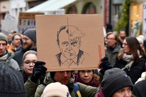 Heidelberg, Germany - February 12th 2025: Person holding up sign comparing CDU politian Friedrich