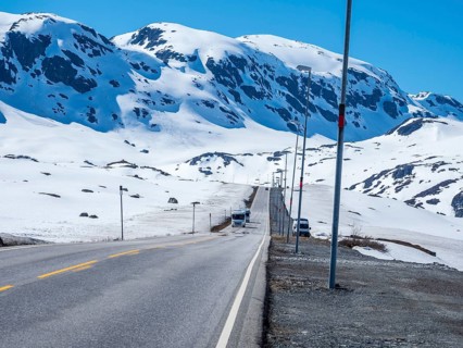Camper vans driving through snowy high mountain landscape, Haukelivegen road, E134, Norway, Europe