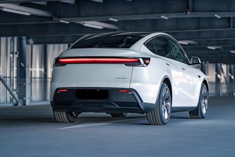 Rear of a modern electric car with eye-catching LED strip in a multi-storey car park, Tesla New