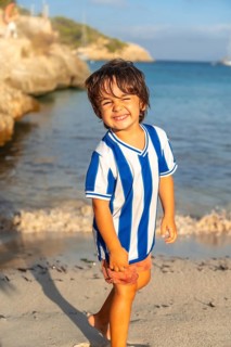 Happy child walking on the beach of s'amarador in mallorca, spain, enjoying summer holidays by the