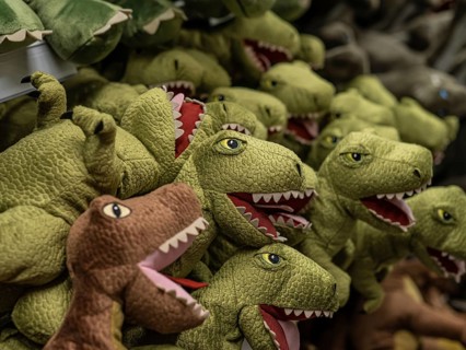 Long row of soft toy dinosaurs in a shop