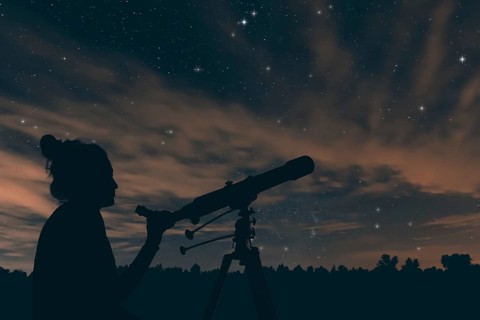 Woman with telescope. Night sky, with clouds and constellations, Aquarius, Aguila, Scutum,