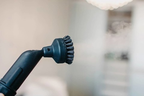 Steam cleaner's brush head with a blurry white background