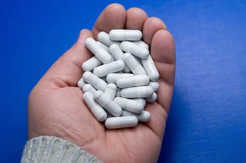 Large white pills fell from a large white bottle. Concept of drugs. Life without drugs and