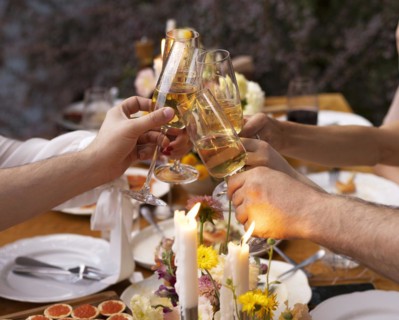HAppy friends saying cheers and showing their champagne glasses full of sparkling wine to each