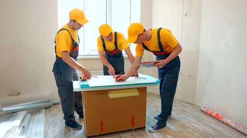 Preparatory phase of house renovation. Working group is studying a plan of apartment. Business