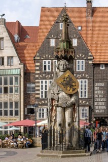 Stone statue with armour and coat of arms Bremen Roland on the market square in the old town of