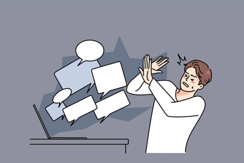 Stressed man overwhelmed with online negative comments and messages on computer. Unhappy guy