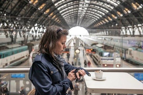 Woman in a Restaurant Drinking Coffee and Looking at Her Watch in Railroad Station in Milan,