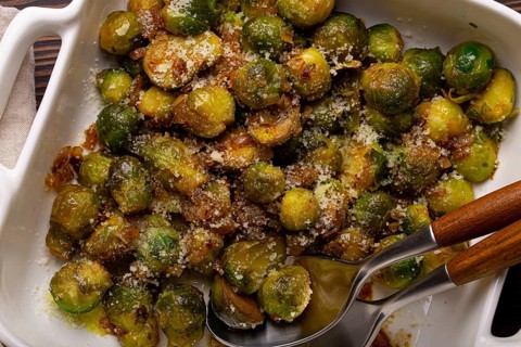 Healthy vegetarian dish roasted brussels sprouts with butter and parmesan cheese in white ceramic