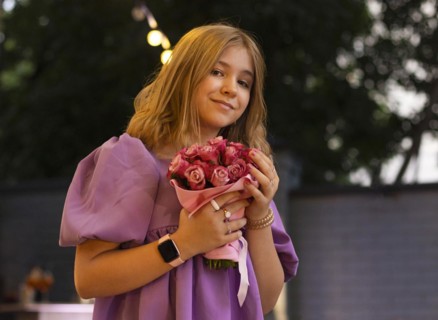 Cute teen girl with rose flowers. Child playing in summer garden. Kids gardening. Children play
