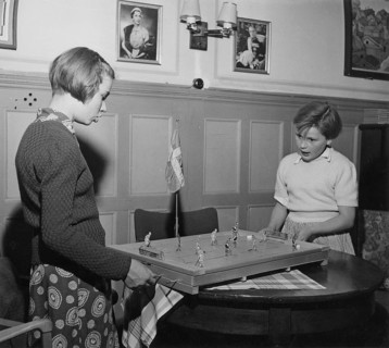 In the 1950s. Two girls are playing the Ice Hockey game Puck. Manufactured by Swedish company