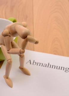 Letter of warning on a table, desperate figure sitting on a cup