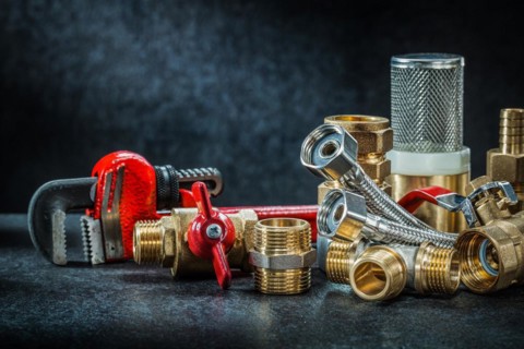 Plumbing brass pipe connectors on dark background