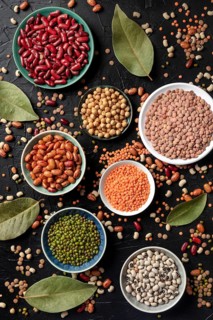 Various legumes, shot from the top on a dark background. Lentils, soybeans, chickpeas, red kidney