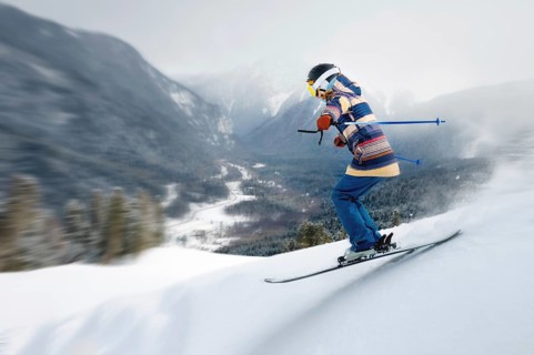 A female athlete skier rides a freeride in a winter forest in the mountains. Jump against the
