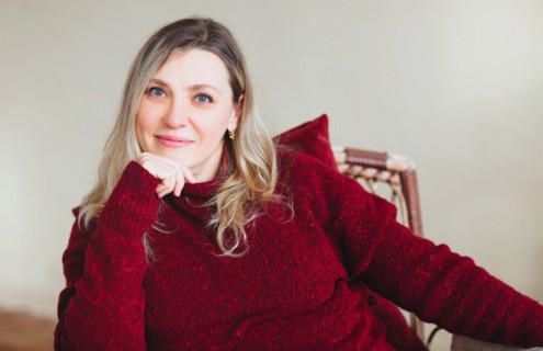Attractive middle aged happy woman sitting and relaxing on comfortable chair at home on weekend,