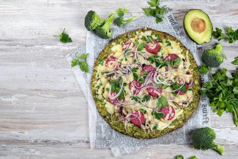 Food, Crust Broccoli base low carbs keto pizza with salami, avocado on vintage newspapper. Top view