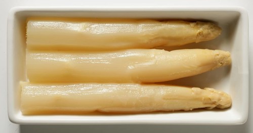 Asparagus in a white dish, three delicious pieces in an rectangel plate