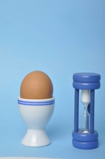 Boiled egg and hourglass on a blue background