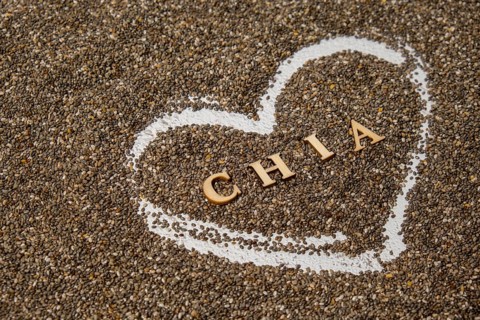 Heart made of chia seeds with word CHIA inside background. Healthy superfood rich in Omega 3 fatty