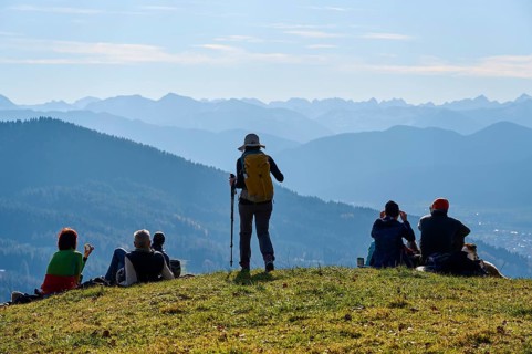 Hikers rest on the summit of Sonntratn, also known as Schürfenkopf, and look into the Karwendel,