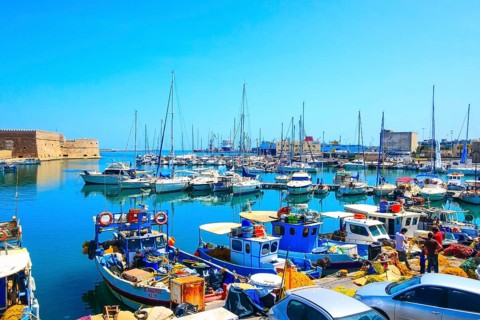 Heraklion, Greece, April 27, 2019: Crete island old harbor with fishing boats and Venetian fortress