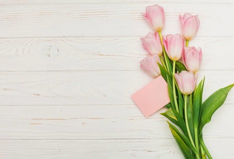 Tulip bouquet with empty card wooden table. High resolution photo