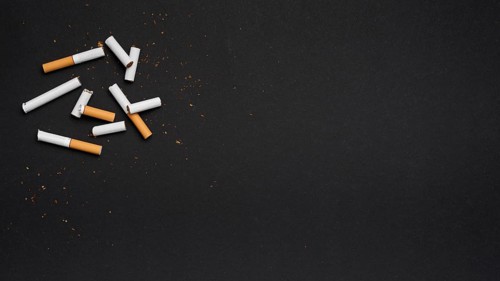 Top view broken cigarette with tobacco black backdrop